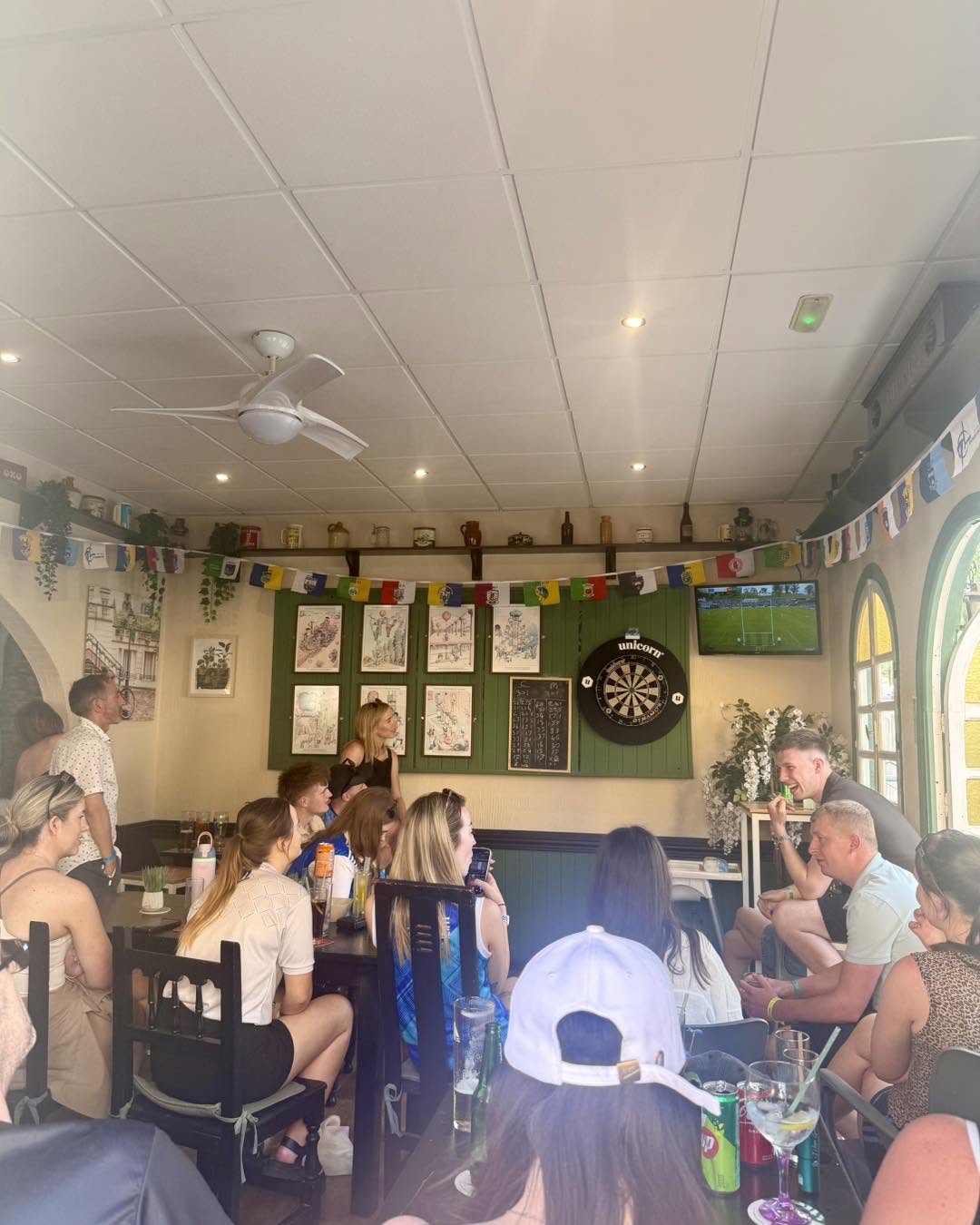 Inside the bar with dartboard and live sport on screen