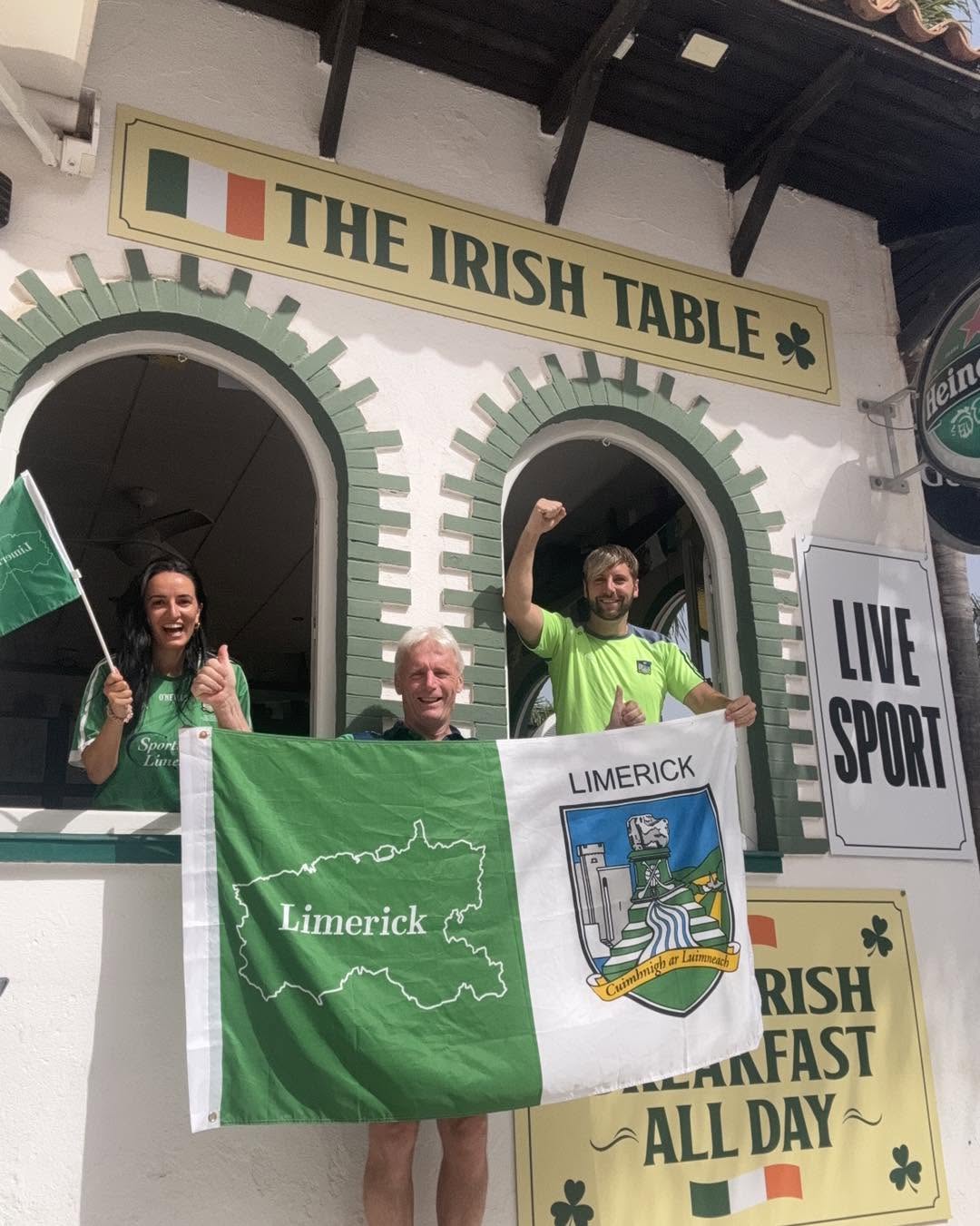 The Irish Table Torremolinos exterior with Frank, Finola and family holding a Limerick flag beneath the signage